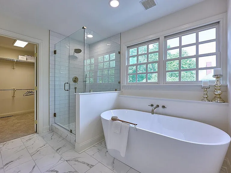 Beautifully remodeled bathroom with subway tile and warm wood vanity
